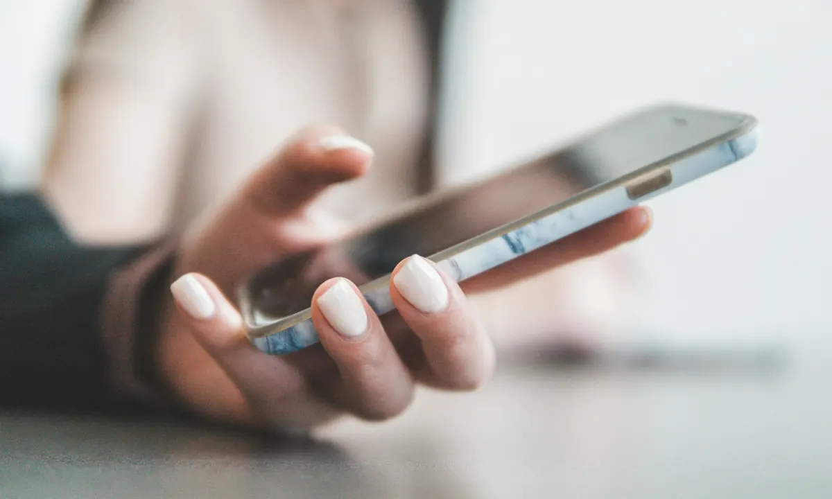 Hands typing a message on a smartphone